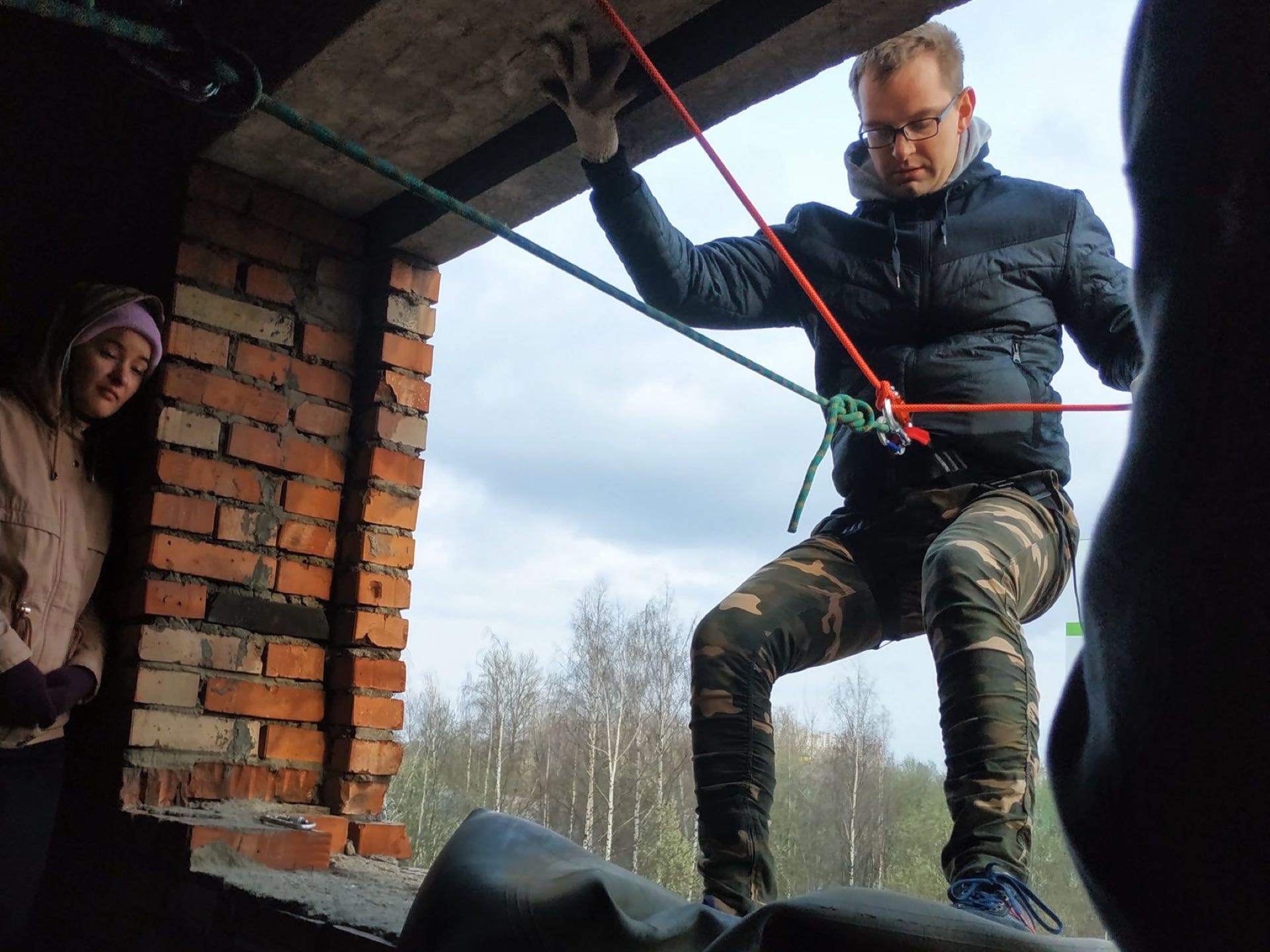 Участник спускается по верёвке из окна